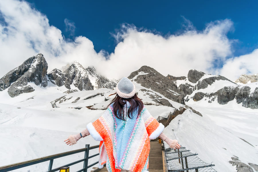 mujer frente a montaña de nieve china
